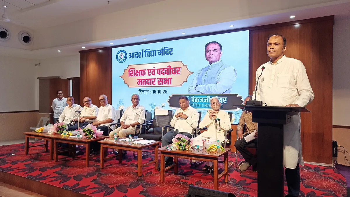 a man speaking at a podium while seated officials sit on a stage in front of a large projected backdrop - Adarsh Vidya Mandir (Gandhibagh)