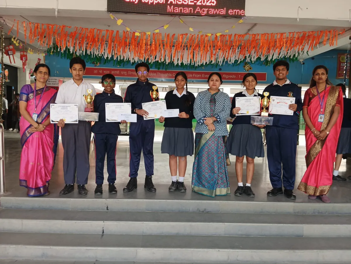 Group photo of students and teachers holding certificates and trophies at Bhavan's BVM Ashti