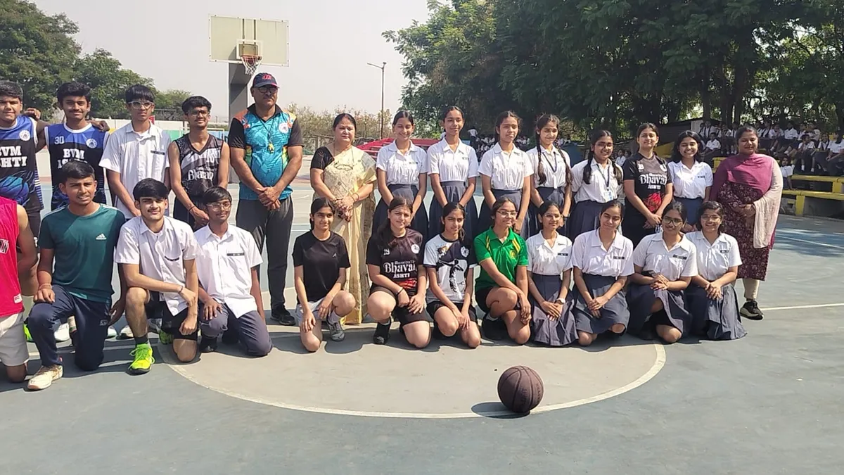 Group photo of students and teachers posing on an outdoor basketball court with a basketball in front, Bhavan's BVM Ashti
