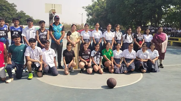 Group photo of students and teachers posing on an outdoor basketball court with a basketball in front, Bhavan's BVM Ashti