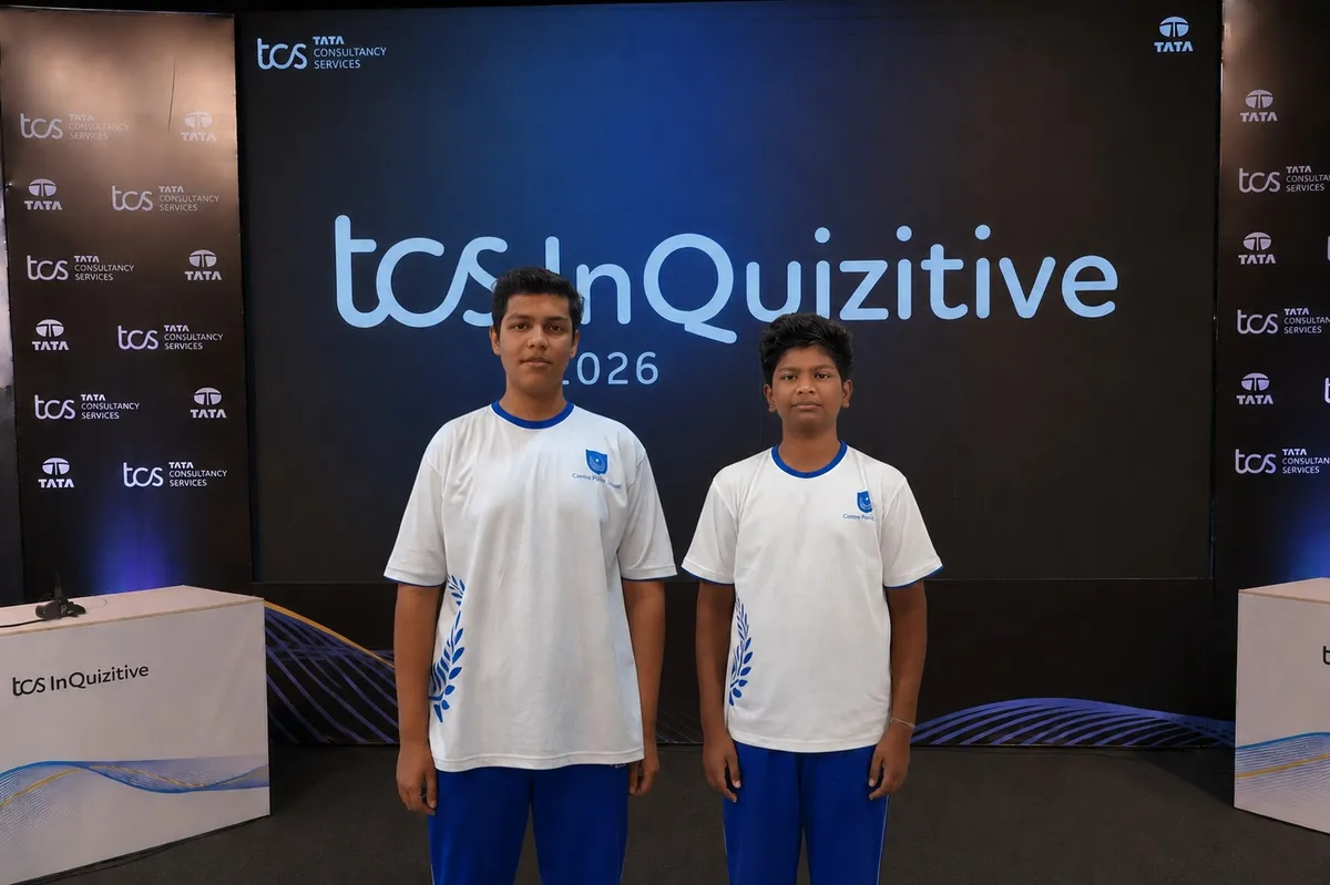 Two students in white and blue uniforms on stage at TCS InQuizitive 2026 event, CPS (Katol Road)