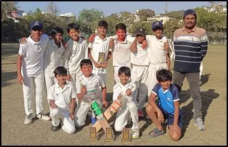 CPS (Katol Road) cricketers in white uniforms with coach and trophy