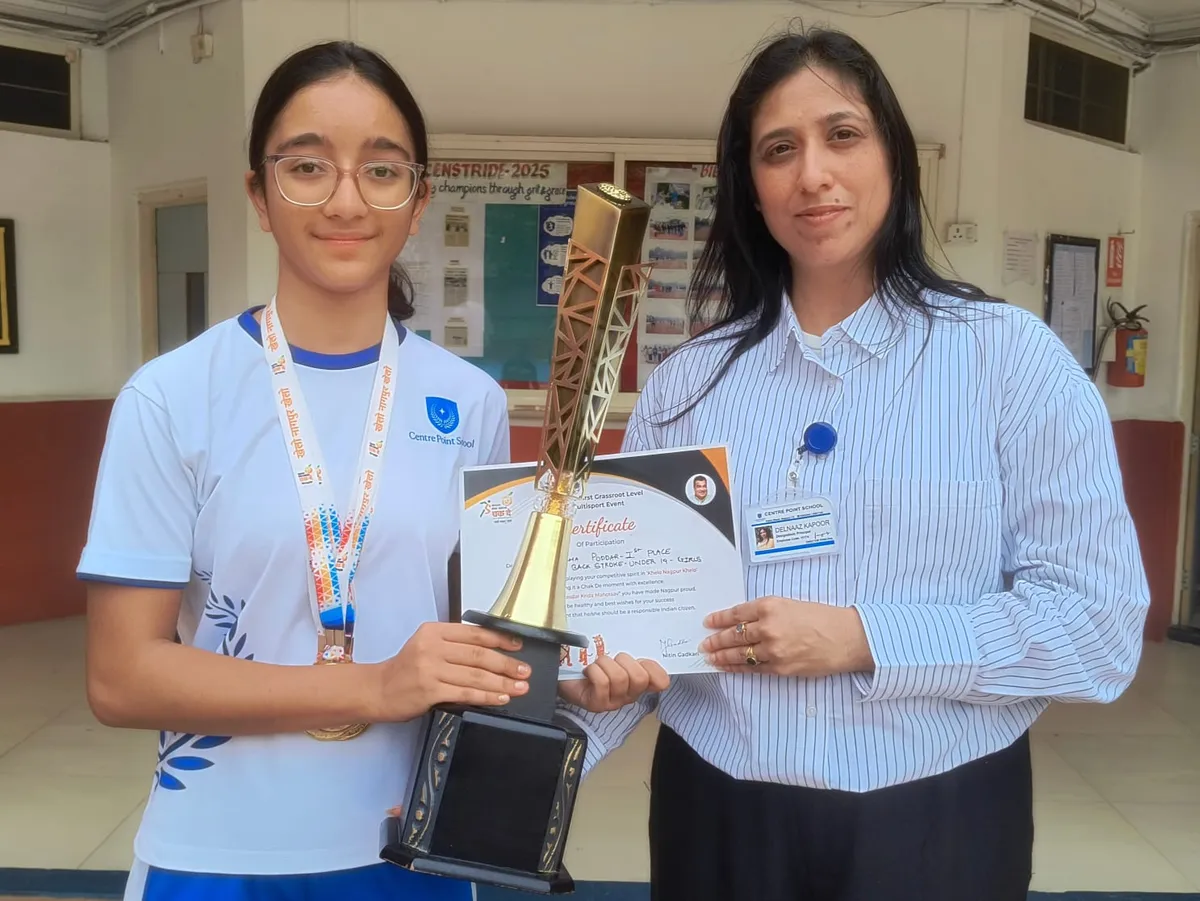 Aisha Poddar wearing a medal and holding a large trophy and certificate with a woman in a striped shirt at CPS (Katol Road)