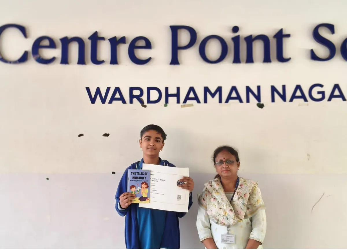 A student in a blue jacket holding a certificate and a book stands beside a woman in a floral top in front of CPS (Wardhaman Nagar) name wall.