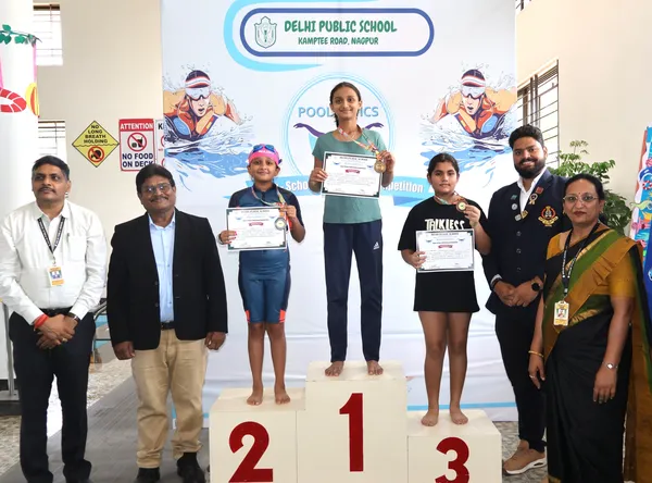 Young swimmers with medals and certificates on podium at DPS (Kamptee Road) Poolympics 4.0