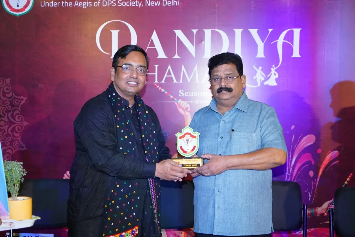 Two men on a stage hold a small trophy together in front of a decorated event backdrop. - DPS (Lava)