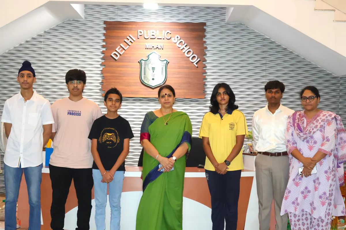 Group photo of students and staff in front of a DPS (Mihan) signboard in a lobby