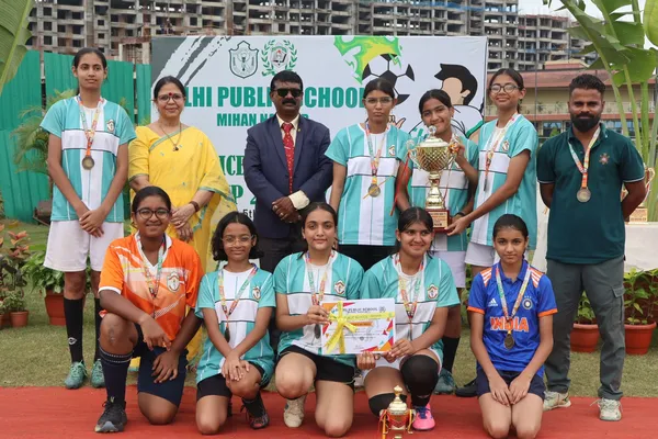 Group photo of girls in teal and other jerseys with medals, trophy and certificate at DPS (Mihan)