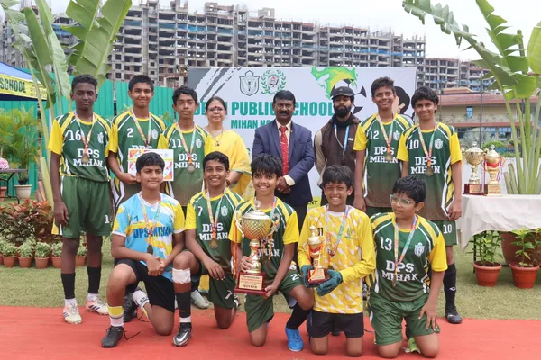 Group photo of boys in green and yellow jerseys with medals and trophies at DPS (Mihan)