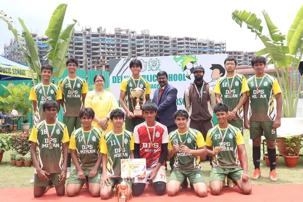 Group photo of boys in green and yellow football jerseys with medals, trophy and certificate at DPS (Mihan)