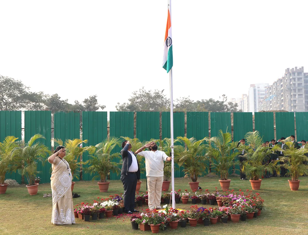 Three people saluting at a flagpole with the Indian flag at DPS (Mihan)
