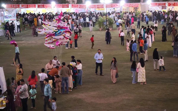Large crowd on a lawn at an evening fair with stalls and balloons at DPS (Mihan)