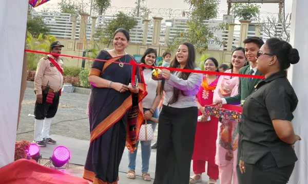 A woman cuts a red ribbon at an inauguration at DPS (Mihan), with others including a student and a guard gathered nearby