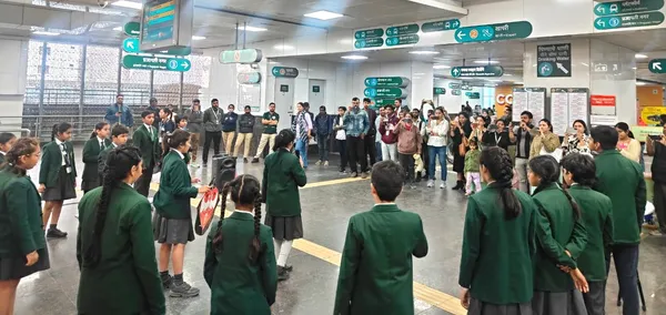 Students in green uniforms stand in a circle performing in a metro station concourse while commuters watch.
