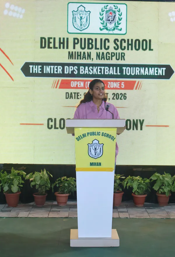 A girl speaking at a podium in front of a large screen for a basketball tournament closing ceremony. - DPS (Mihan)