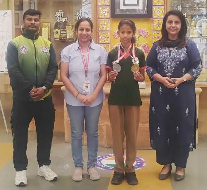Jain International student Akshada Shahu with adults holding gold and silver medals