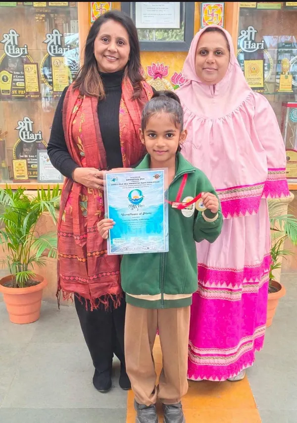 Nivisha Gaikwad holding a certificate and medal at Jain International