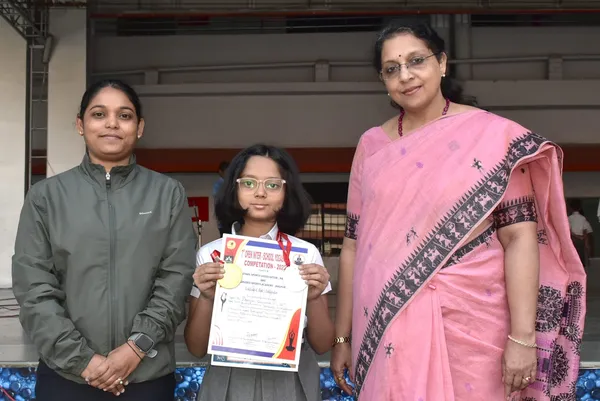 Pranjal Gawande holds a certificate and medal, flanked by two women, at Narayana Vidyalayam