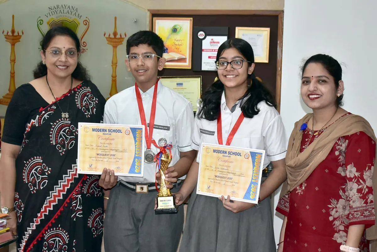 Two students with medals hold certificates and a trophy, standing between two women at Narayana Vidyalayam.