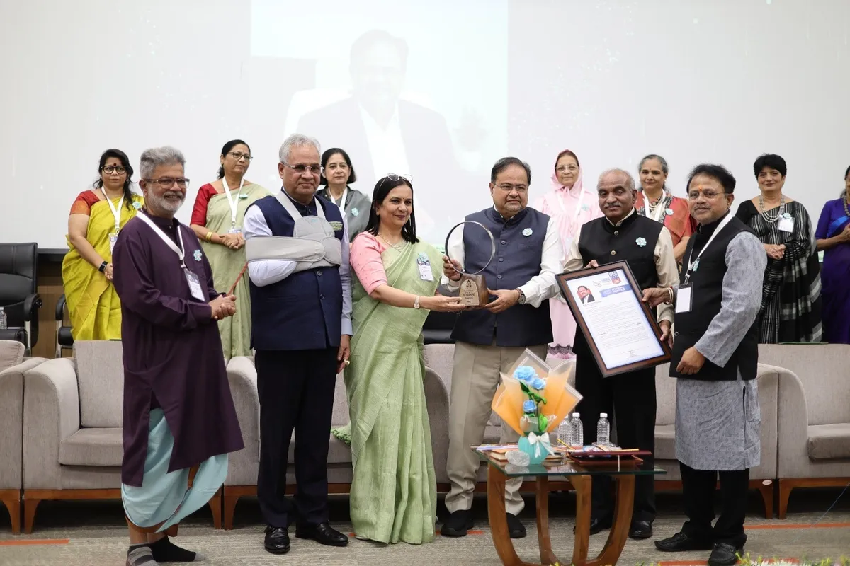 Group on stage with a trophy and framed certificate in front of a projected screen at IPEC 2026, The South Public School