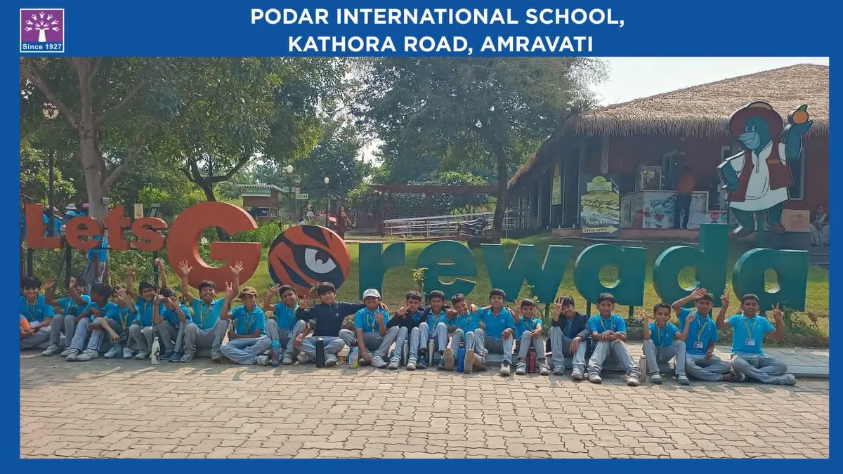 group photo of about two dozen students in blue shirts posing in front of large Let's Go Gorewada letters, inside a framed school header - Podar International (Amravati)