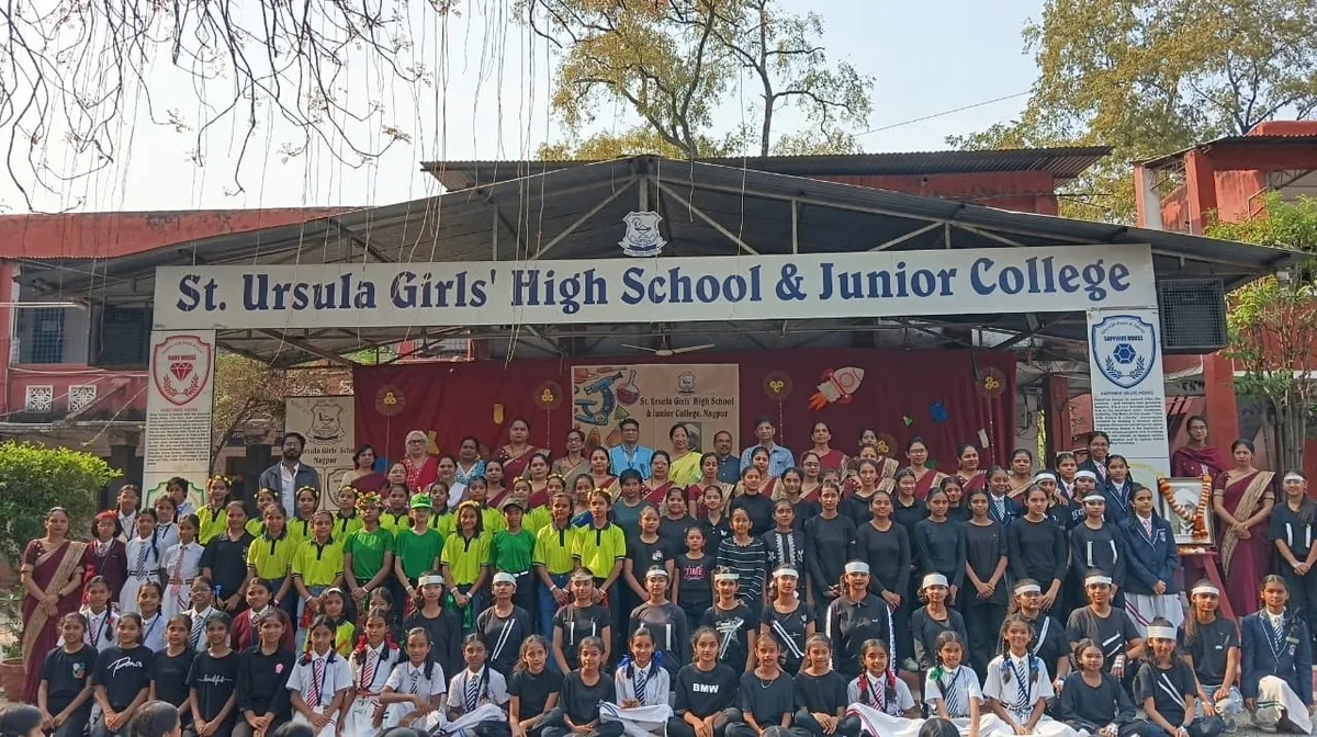 Group photo of St. Ursula students and teachers on school stage