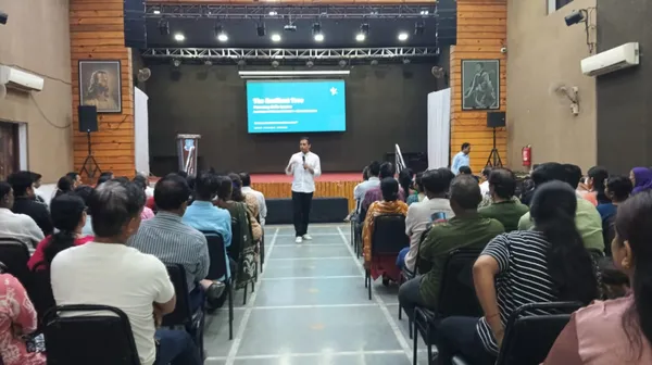 A speaker addresses seated adults in an auditorium at St. Ursula.