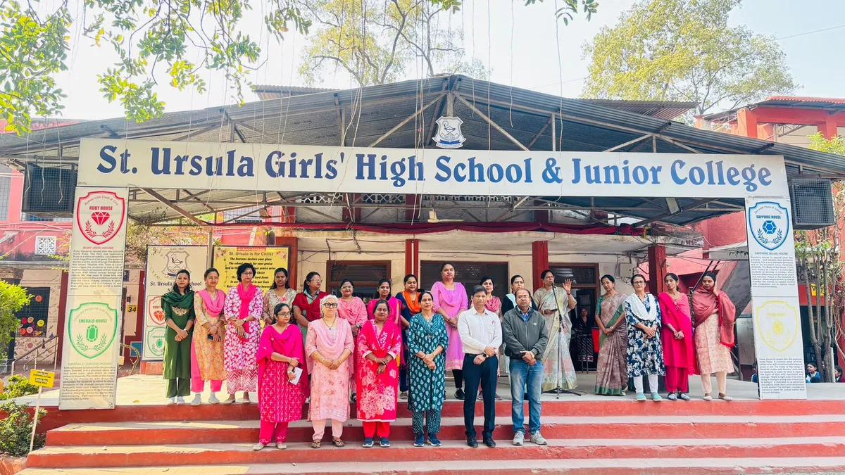 Group photo of staff members standing on red steps in front of St. Ursula Girls' High School & Jr. College building