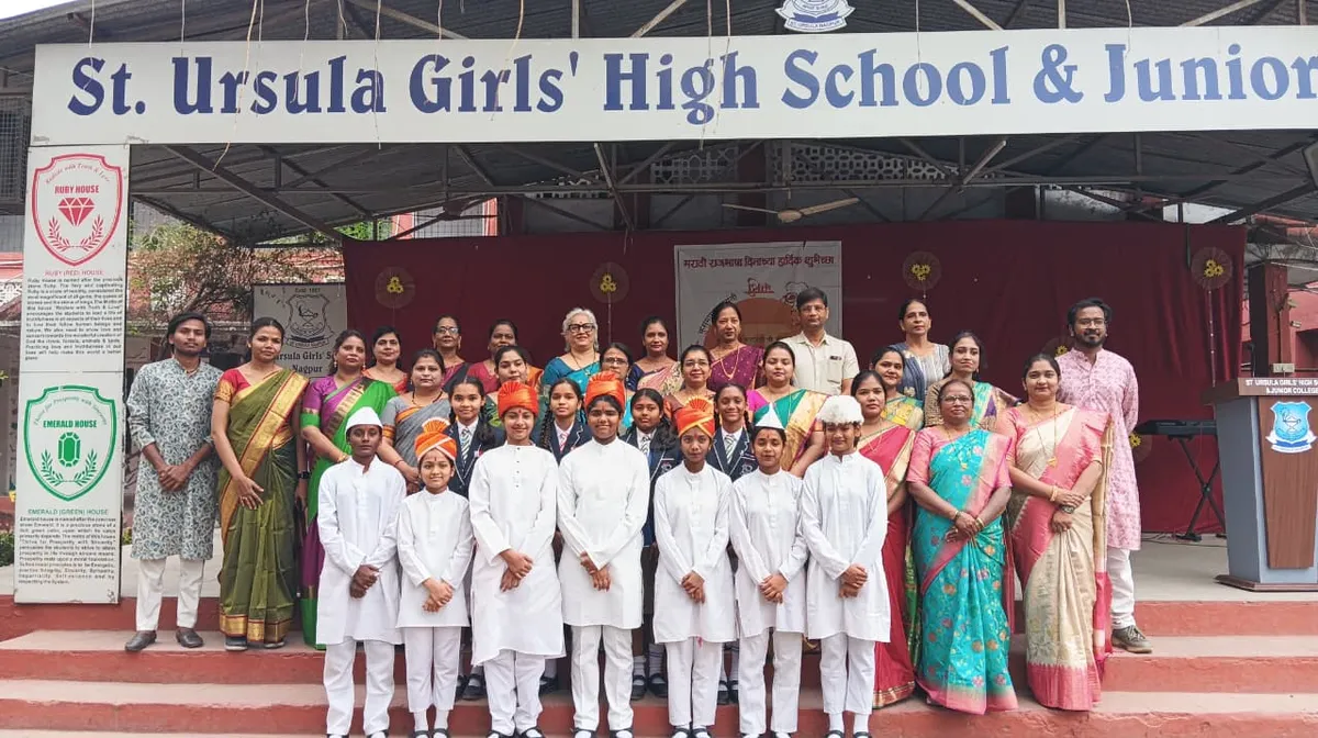Teachers in traditional attire and students in white outfits and caps on school steps at St. Ursula