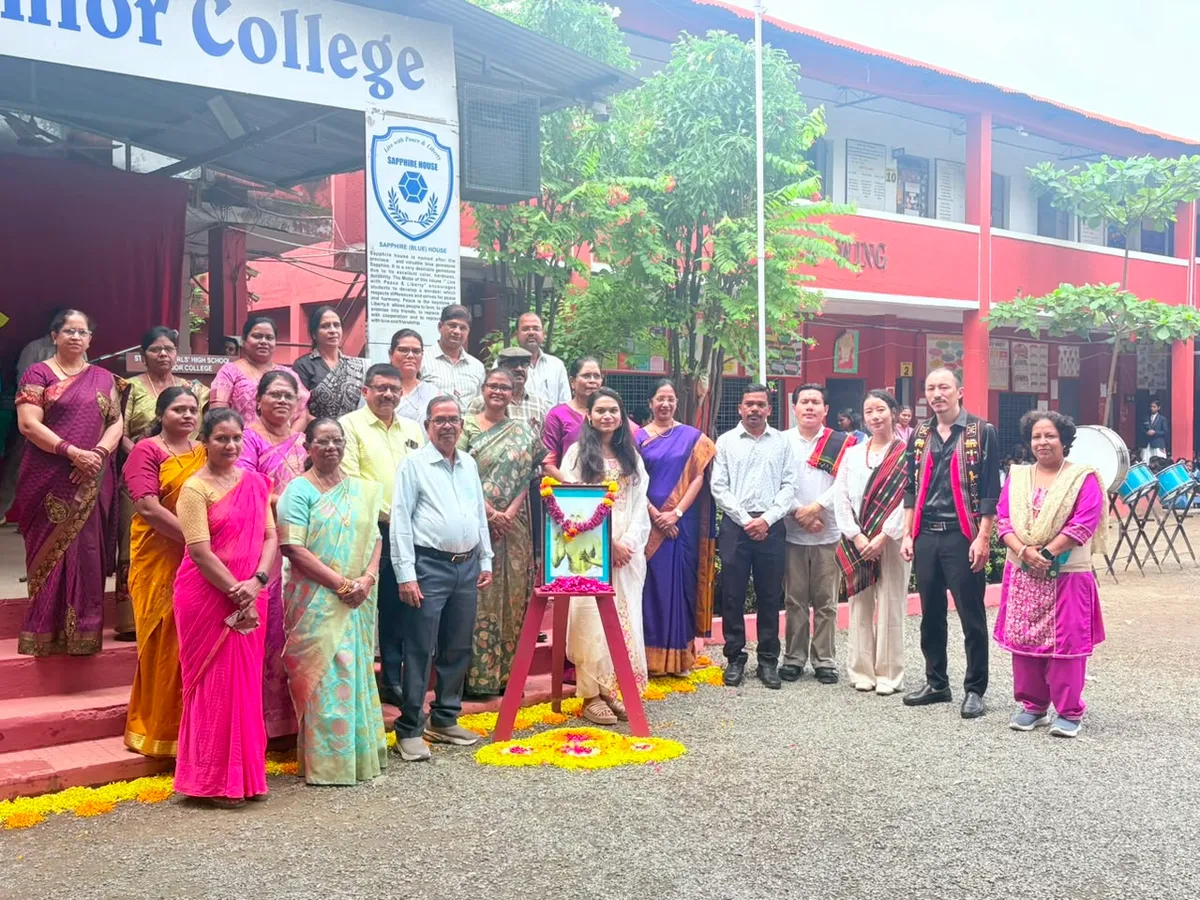 Group photo of people including guests and staff at St. Ursula's World Tribal Day event in front of the school building