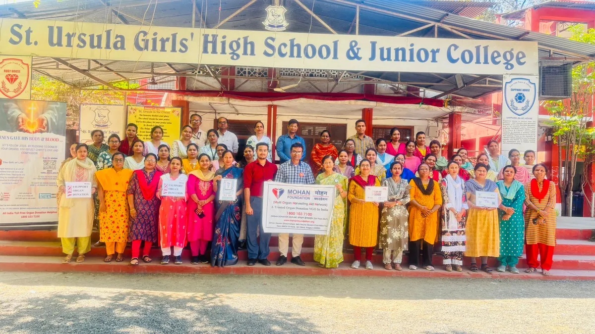 Group photo of women and men standing on steps in front of St. Ursula school building, several holding placards